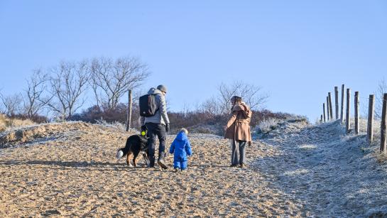 Een gezin wandelt door de duinen