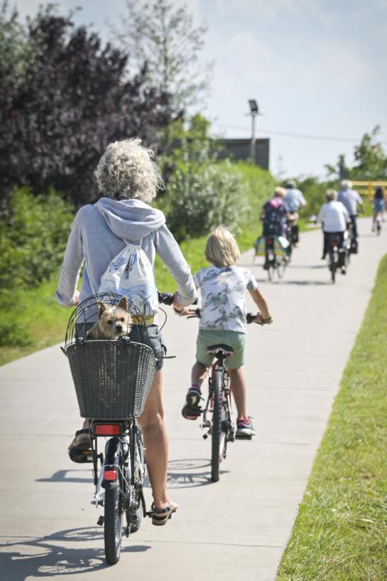 Moeder fietst samen met dochter en hond