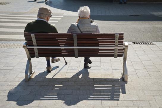 Twee senioren rusten uit op een zitbank
