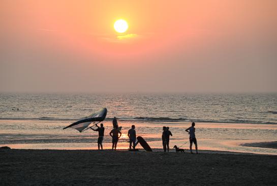 Surfers bij zonsondergang